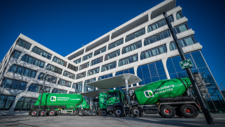 Heidelberg Materials cement mixer trucks parked outside a modern office building