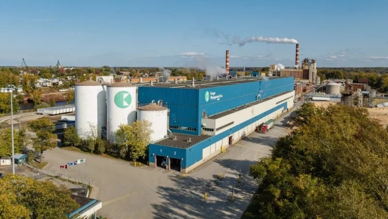 Industrial processing facility with storage tanks and smokestacks
