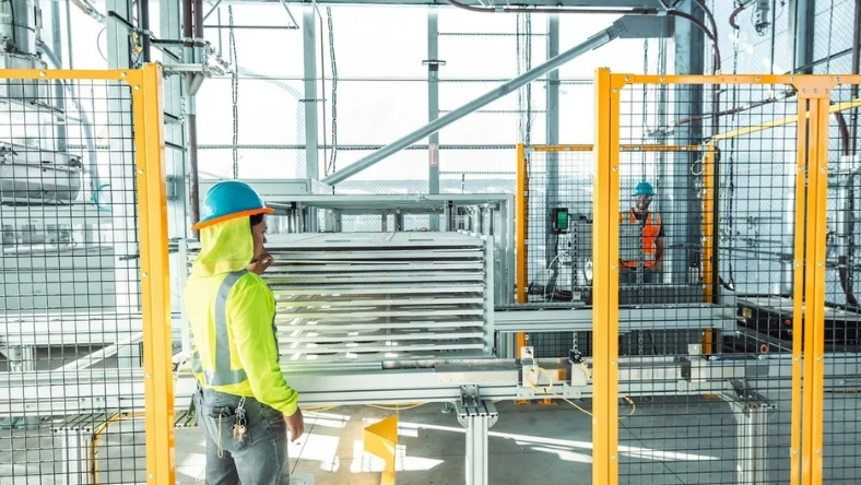 Technicians monitoring carbon capture system inside industrial facility